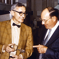 In a historical photo, two men converse